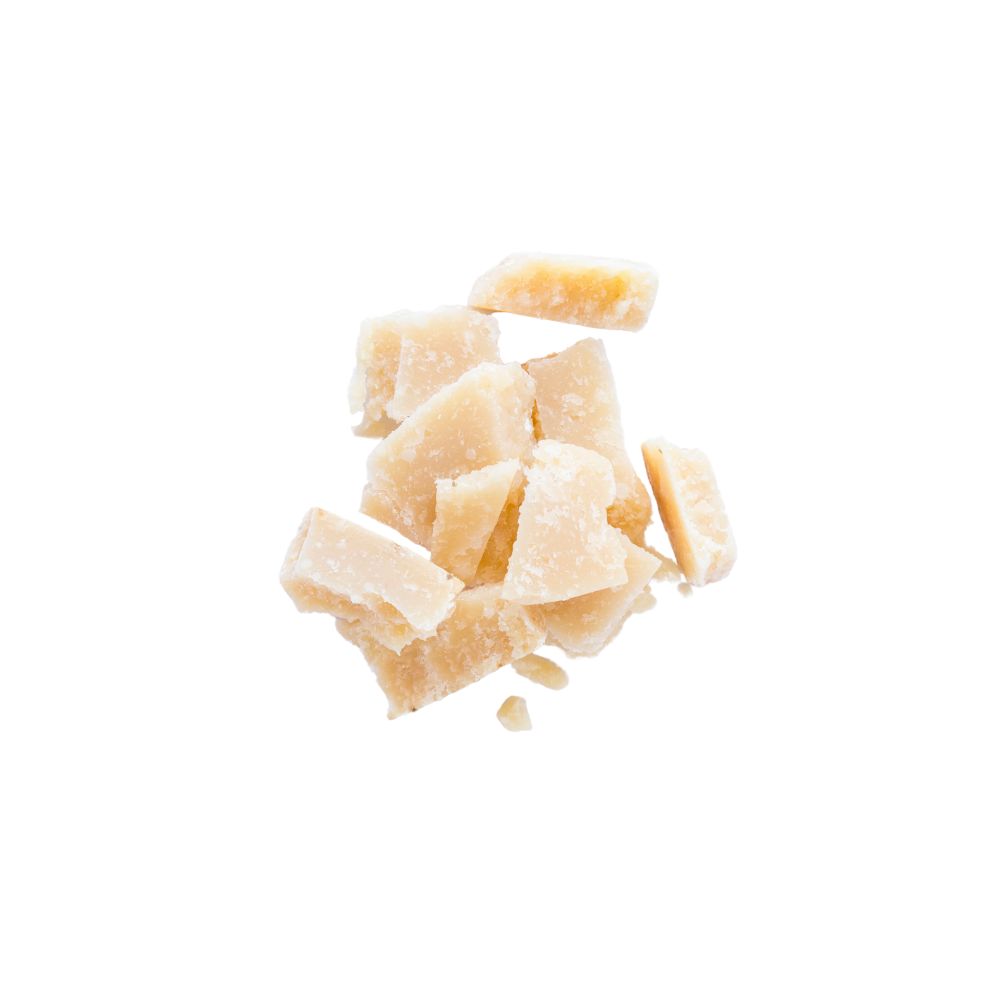 A close-up view of a pile of raw sugar crystals on a clean white surface, showcasing their natural texture and color.